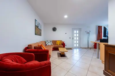 a living room with two red chairs and a couch at Cesa Primula in Canazei