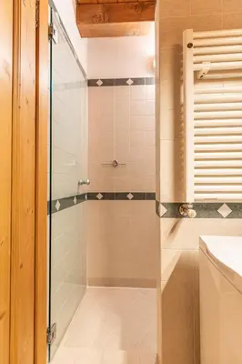 a bathroom with a shower with a glass door at Casa Noce, tranquilla e immersa nella natura in Cortina dʼAmpezzo