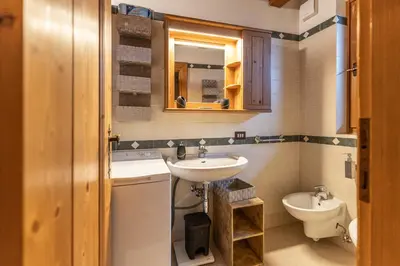 a bathroom with a sink and a toilet at Casa Noce, tranquilla e immersa nella natura in Cortina dʼAmpezzo