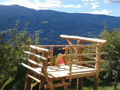 a wooden chair sitting on top of a mountain at Bärntalerhof in Falzes