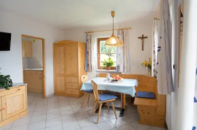 a kitchen with a table and a cross on the window at Bärntalerhof in Falzes