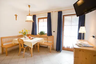 a dining room with a white table and blue curtains at Bärntalerhof in Falzes