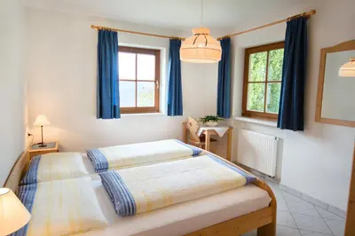 a bedroom with two beds and two windows at Bärntalerhof in Falzes