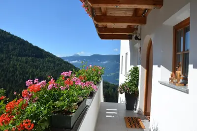 a balcony with flowers on the side of a building at Bärntalerhof in Falzes