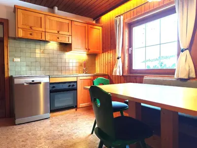 a kitchen with wooden cabinets and a table and a window at Almliesl THUR-746 in Lovara
