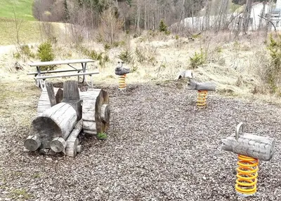 a group of wooden logs in a park with a bench at Almliesl THUR-746 in Lovara