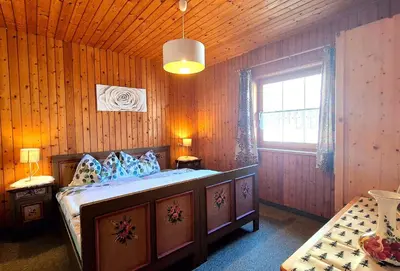 a bedroom with a bed in a wooden room at Almliesl THUR-746 in Lovara