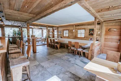 a dining room with wooden walls and tables and chairs at Chalet Mornà in San Martino in Badia