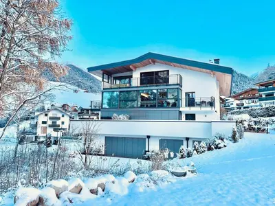 a bedroom with a large bed with two lamps on tables at Unterkircher Mountain Stay Relax in Terento