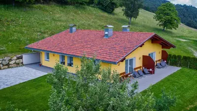 a yellow house with a red roof on a hill at Appartament Eichnerhof in Chienes