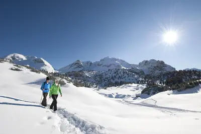two people walking up a snow covered mountain at Appartament Eichnerhof in Chienes