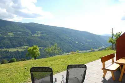 a table and chairs on a patio with a view of a mountain at Appartament Eichnerhof in Chienes