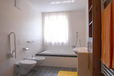 a bathroom with a toilet and a tub and a sink at Appartament Eichnerhof in Chienes