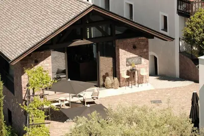 a room with a table and chairs and a large window at Weingut Pratenberg in Merano
