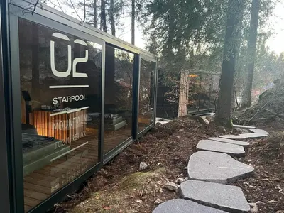 a glass house in the middle of a forest at Camping Castelpietra in Fiera di Primiero
