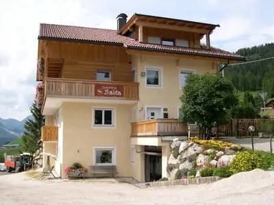 a large house with a balcony on a mountain at Garni Baita in San Cassiano