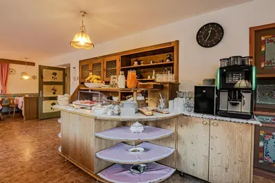 a kitchen with a counter with two purple stools at Garni Baita in San Cassiano