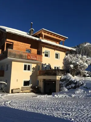 a large building in the snow in front at Garni Baita in San Cassiano