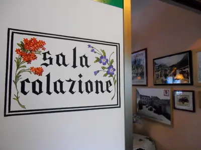 a sign on a wall with flowers on it at Garni al Barance in Selva di Cadore