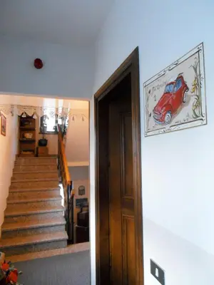 a room with a staircase with a red car picture on the wall at Garni al Barance in Selva di Cadore