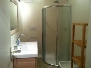 a bathroom with a glass shower and a sink at Casa Laurino In Centro A Bolzano in Bolzano