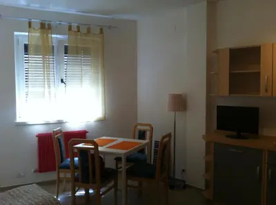 a dining room with a table and chairs and a television at Casa Laurino In Centro A Bolzano in Bolzano