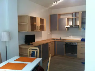 a kitchen with wooden cabinets and a table with a computer at Casa Laurino In Centro A Bolzano in Bolzano