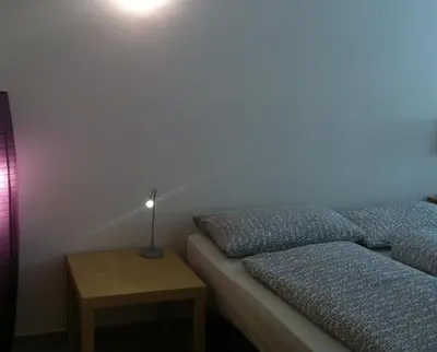a bedroom with a bed and a lamp on a table at Casa Laurino In Centro A Bolzano in Bolzano