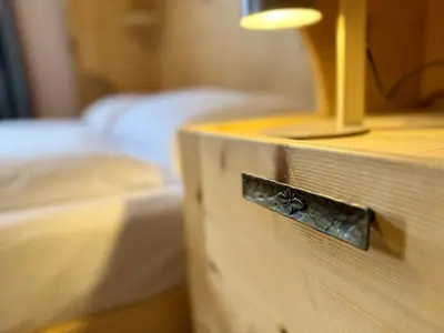 a close up of a wooden drawer in a room with two beds at Dolomites Red Heart Lake View in Masarè