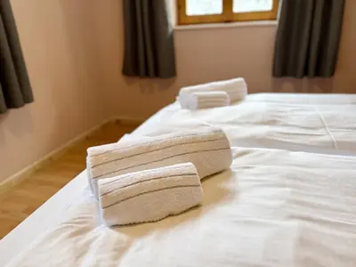 two towels are sitting on top of two beds at Dolomites Red Heart Lake View in Masarè