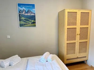 a bedroom with a bed and a cabinet and a picture at Dolomites Red Heart Lake View in Masarè