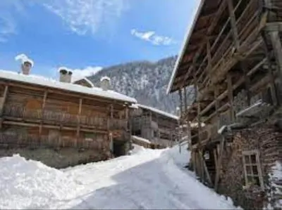 a building with snow on the ground in front of it at Ciesa del Selmo Faure in Sottoguda