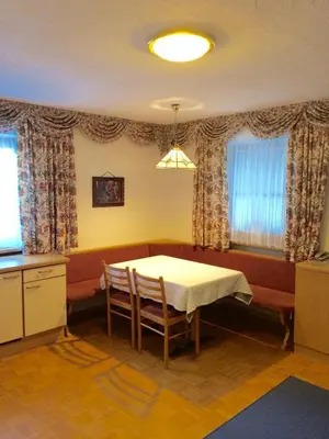 a dining room with a table and chairs and windows at Residence Vajolet San Cassiano in San Cassiano
