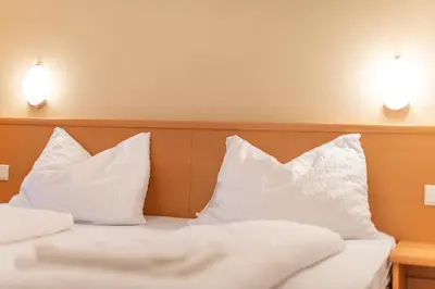 two white pillows on a bed in a hotel room at Angerhof in Caldaro
