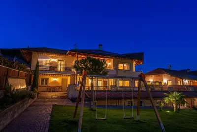 a house with a playground in front of it at night at Angerhof in Caldaro