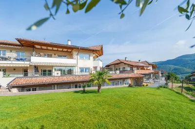 a large house with a green lawn in front of it at Angerhof in Caldaro