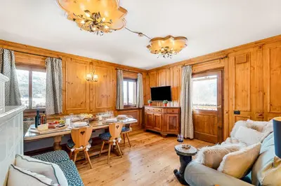 a living room with wood paneling and a table and a couch at Chalet Mortisa, Cortina design apartment in Col