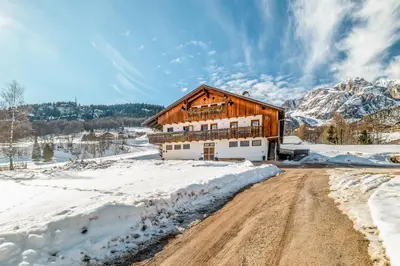 a barn in the snow with a dirt road at Chalet Mortisa, Cortina design apartment in Col