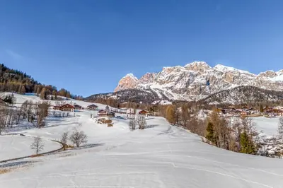 a snow covered mountain with a village in the foreground at Chalet Mortisa, Cortina design apartment in Col