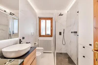 a white bathroom with a sink and a shower at Chalet Mortisa, Cortina design apartment in Col