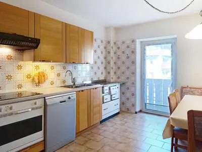 a kitchen with wooden cabinets and white appliances at Apartment Cesa Marco by Interhome in Pozza di Fassa