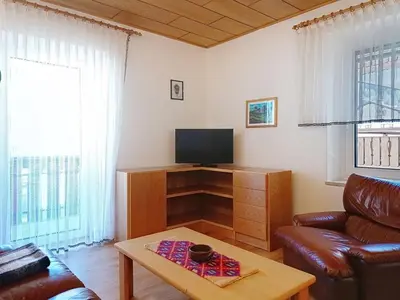 a living room with a couch and a tv and a table at Apartment Cesa Marco by Interhome in Pozza di Fassa