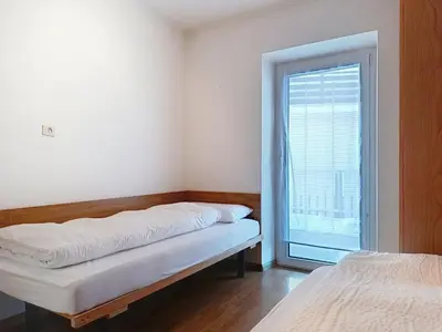 a room with two beds and a window at Apartment Cesa Marco by Interhome in Pozza di Fassa