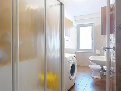 a bathroom with a washing machine and a sink at Apartment Cesa Marco by Interhome in Pozza di Fassa