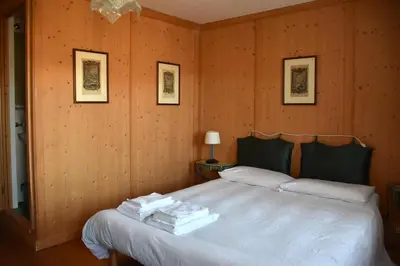 a bedroom with a bed with wooden walls at Mezzodì Locazione Turistica in Colcerver