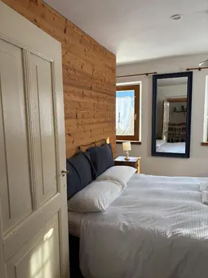 a bedroom with a white bed and a mirror at Mezzodì Locazione Turistica in Colcerver