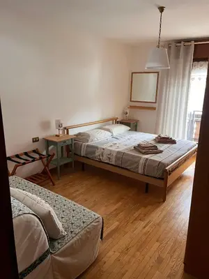 a bedroom with two beds and a table and a mirror at Angolo relax in Cencenighe