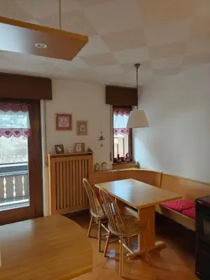 a dining room with a wooden table and chairs at Angolo relax in Cencenighe