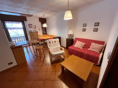 a living room with a red couch and a table at Angolo relax in Cencenighe