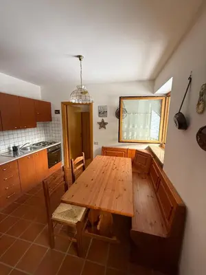 a kitchen with a wooden table and chairs in it at Malga Ciapela e Marmolada a due passi dalle piste in Malga Ciapela